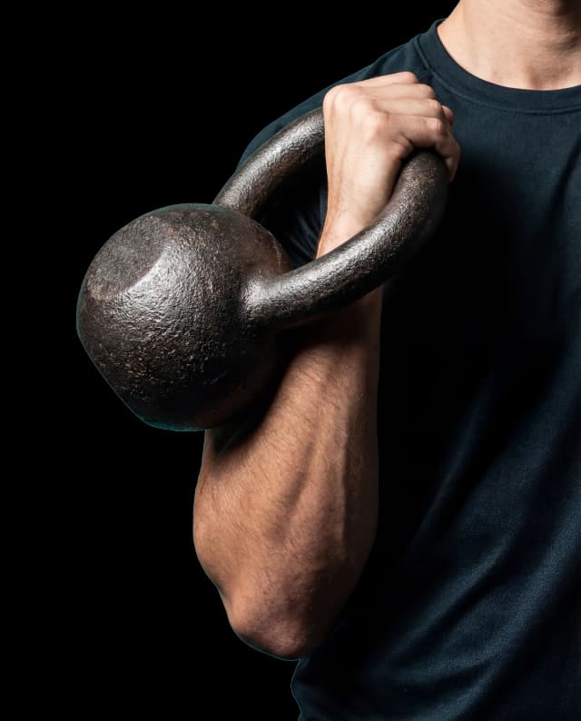 Kettlebell held in rack position showing the starting stance for a FlowTimer complex sequence